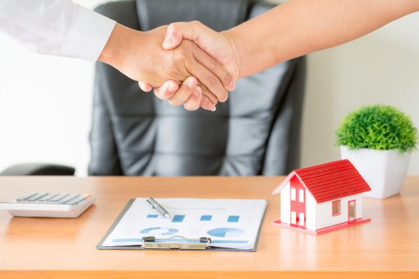 hands of agent and client shaking hands after signed contract bu Solutions